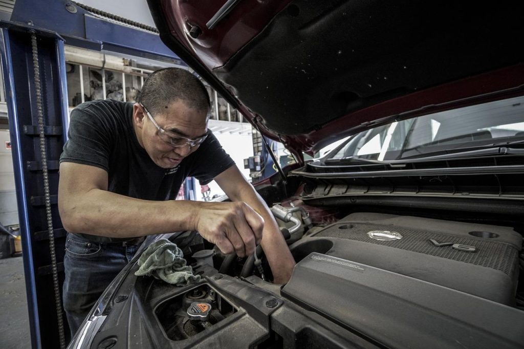 Monteur voert auto reparatie in Den Bosch uit met gereedschap en professionele werkplaats