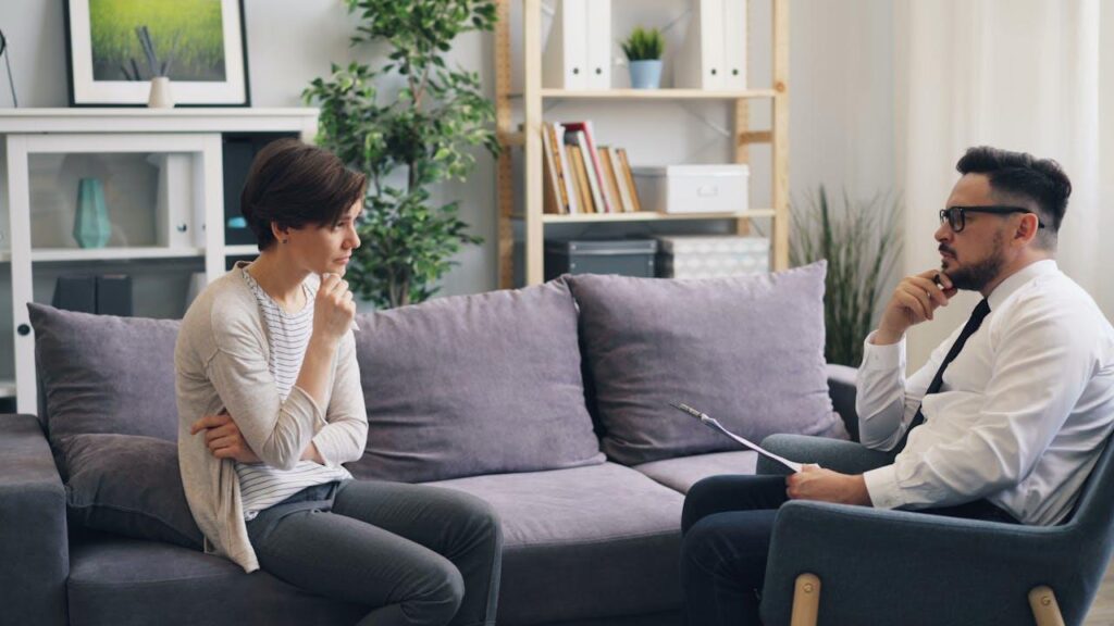 Twee partners in gesprek met mediator over scheiden zonder strijd in rustige omgeving